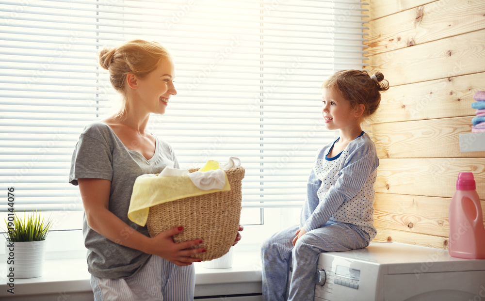 幸福的家庭主妇妈妈和孩子在洗衣机里。