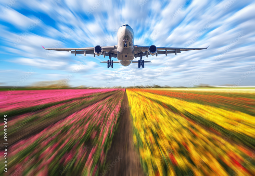 Airplane in motion. Landscape with passenger airplane is flying in blurred blue sky with clouds over