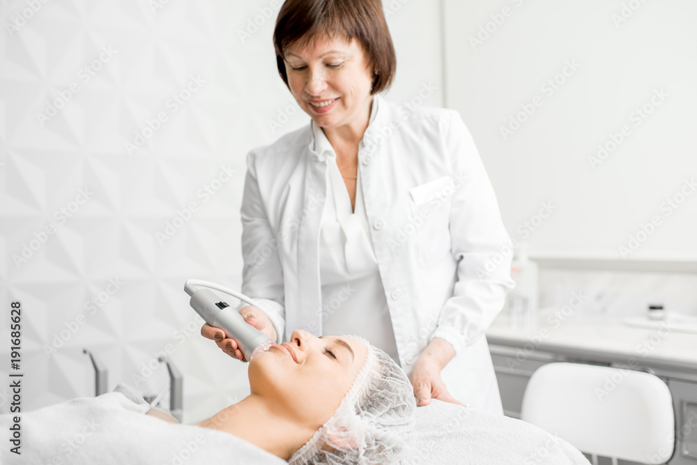 高级女性美容师在豪华医疗度假酒店为一位年轻客户做面部手术