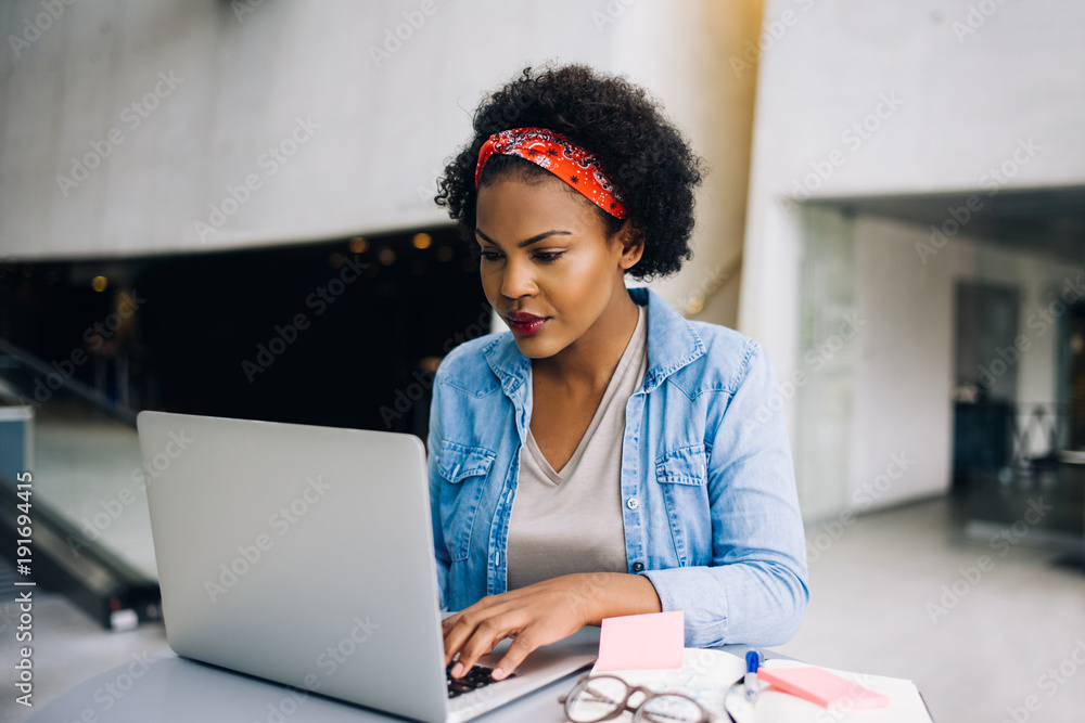 Focused young African female entrepreneur working on a laptop