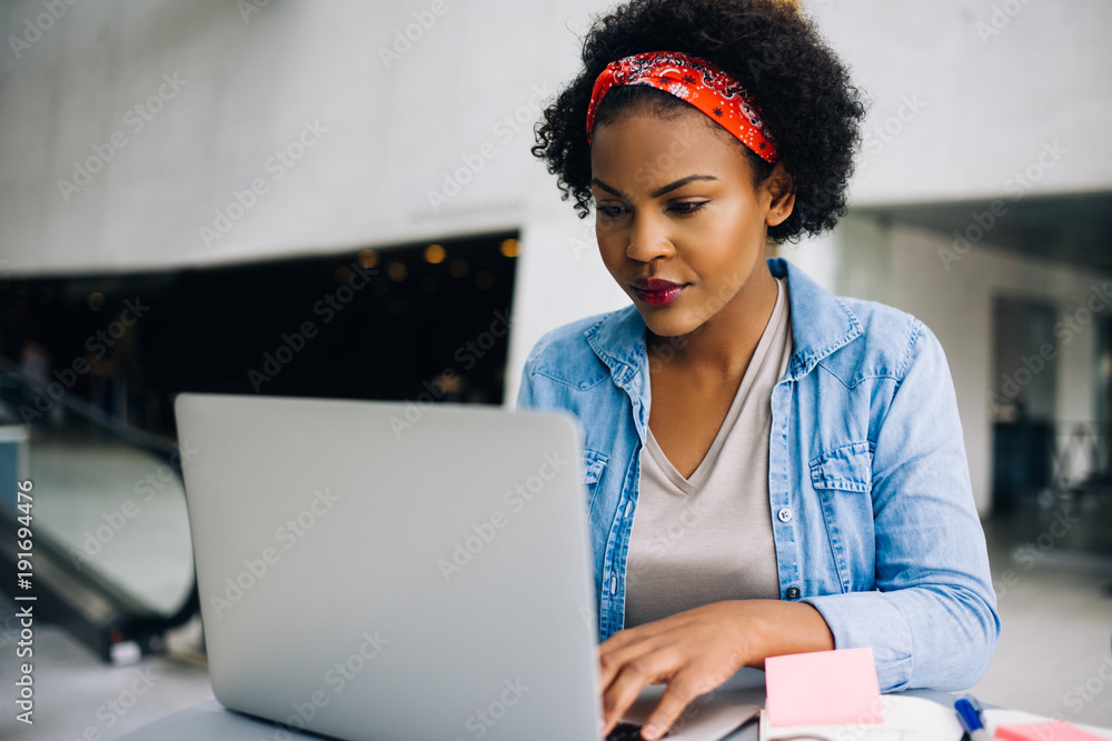 自信的年轻非洲女企业家在笔记本电脑上工作