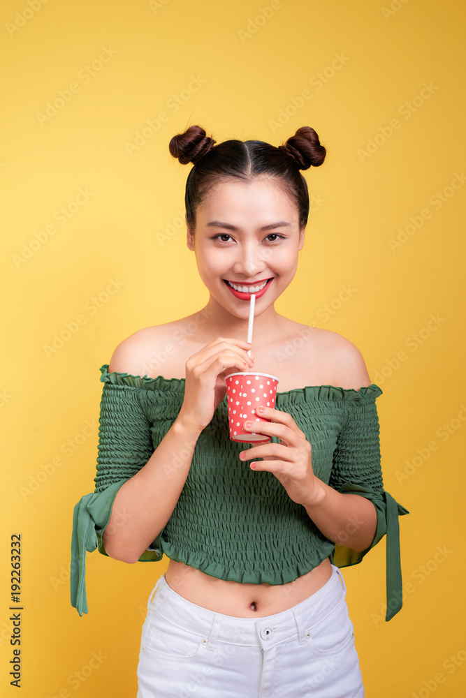 美丽的疯狂微笑的红唇亚洲女女孩用吸管喝可乐