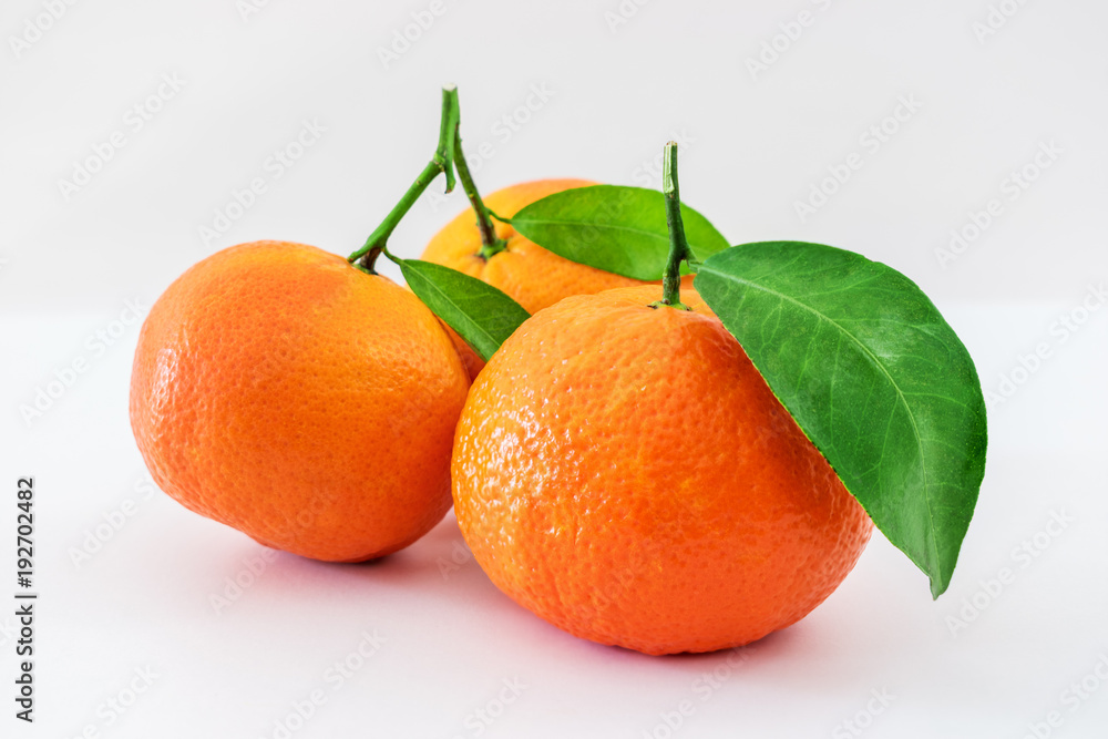 成熟的曼陀罗柑橘，绿色叶子孤立在白色背景上
