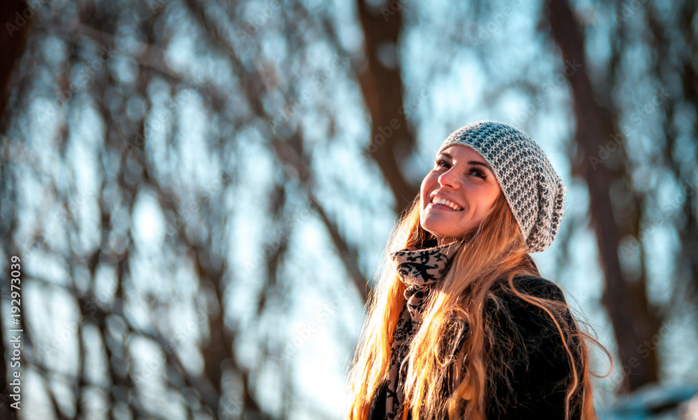 阳光明媚的冬日公园里微笑的女人的画像