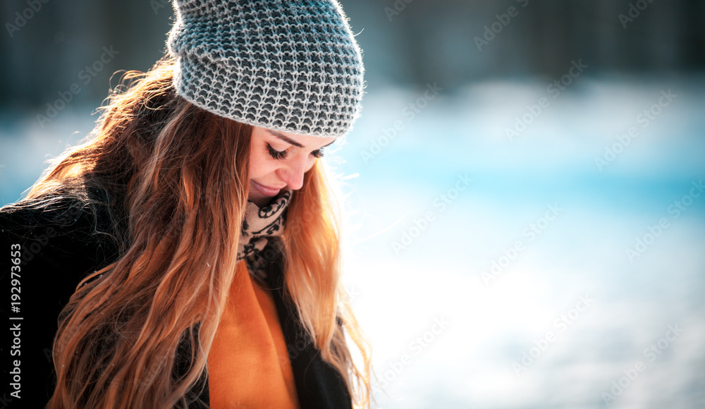 阳光明媚，年轻女子在冬季公园散步