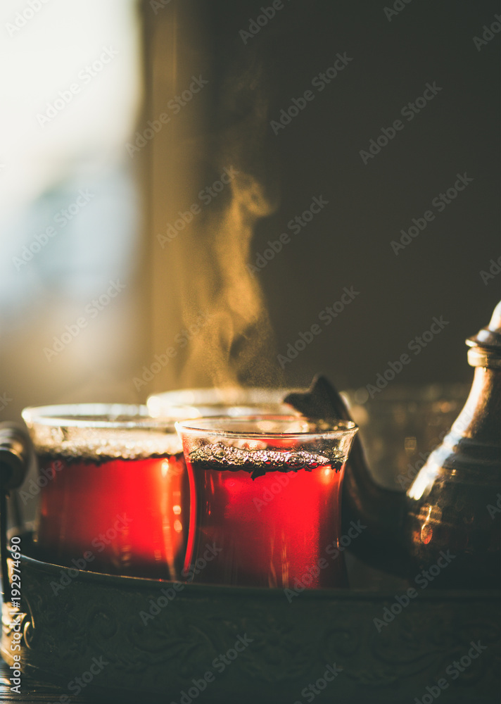 土耳其玻璃杯中的新泡红茶和东方托盘中的茶壶，选择性聚焦，特写，