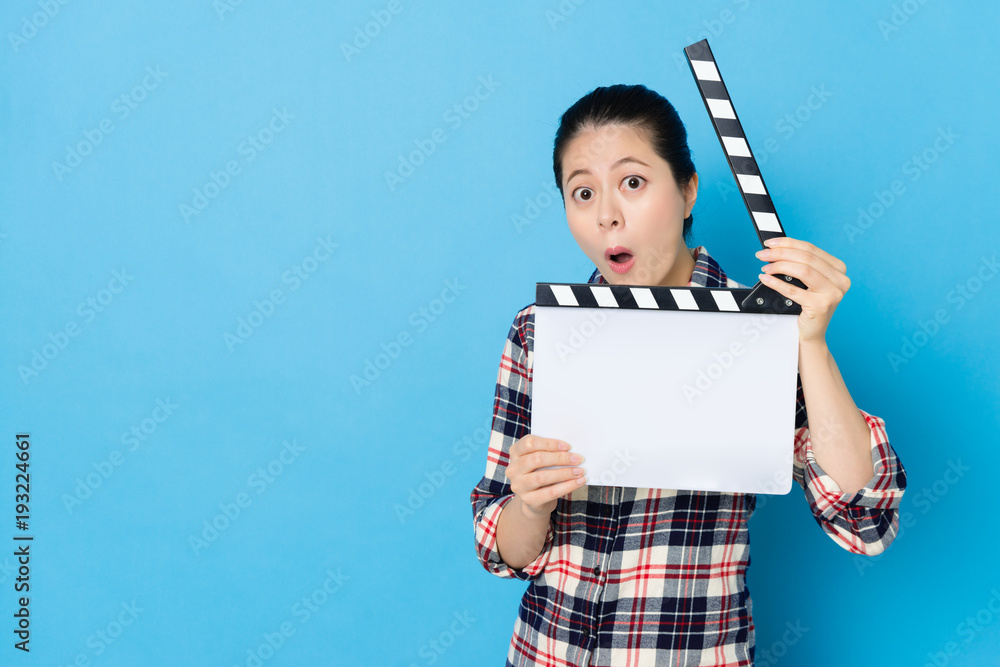 woman playing clapboard looking at camera
