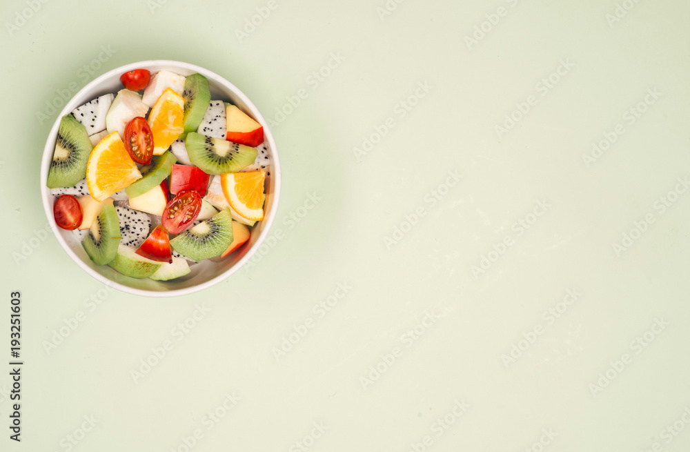 一碗健康的新鲜水果沙拉，木质背景。俯视图。
