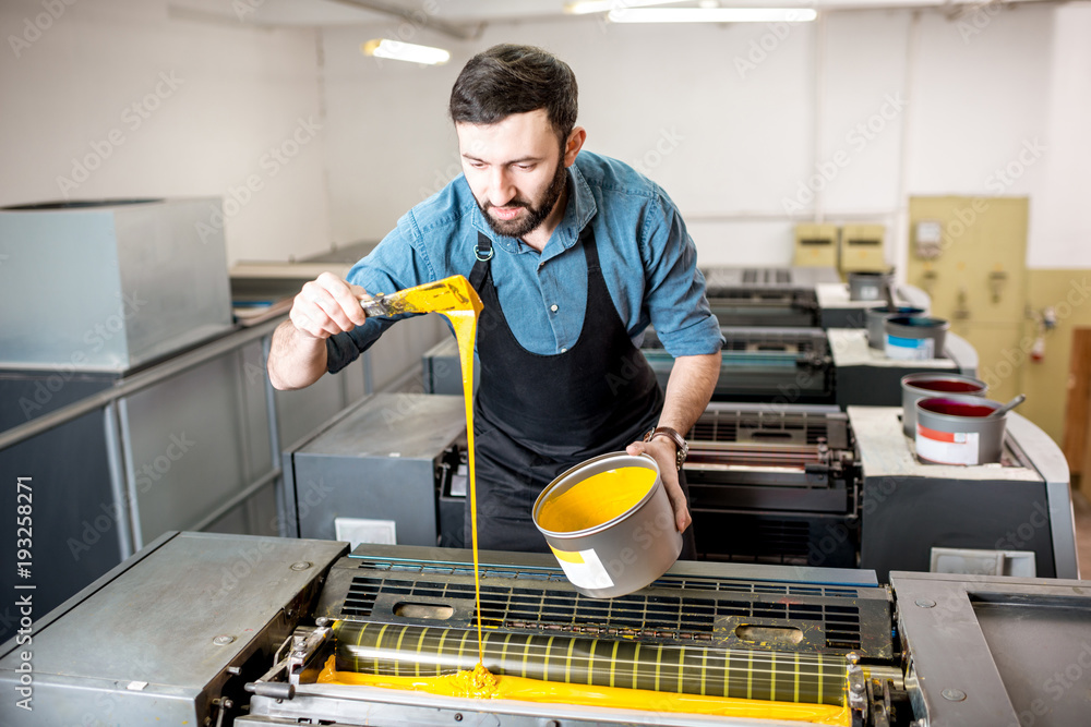 印刷制造厂的胶印机由打字机填充黄色油漆
