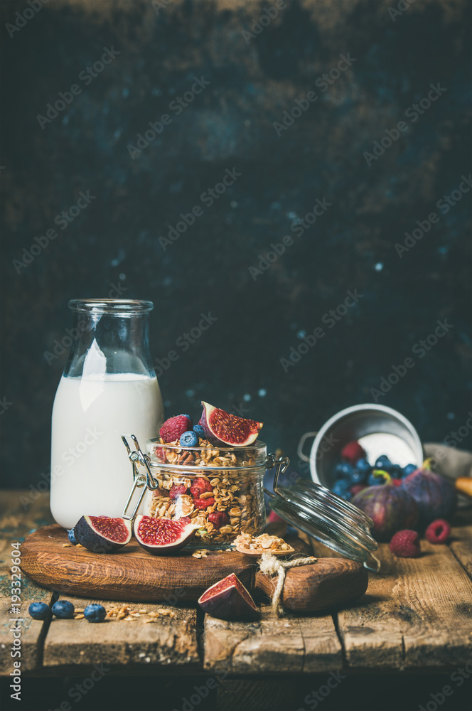 健康素食早餐。燕麦格兰诺拉麦片配瓶装杏仁奶、蜂蜜、新鲜水果和浆果