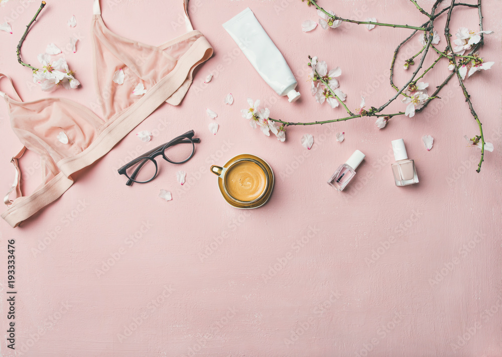 女性晨间仪式概念。女性嫩粉色内衣、眼镜、化妆品的平躺