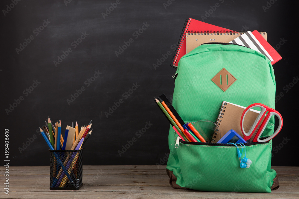 教育理念-学校书包，里面有书籍和其他用品，黑板背景