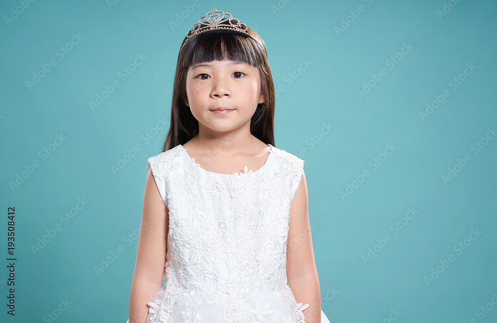 年轻可爱的亚洲小女孩的肖像，穿着像公主。孤立在浅绿色背景上。