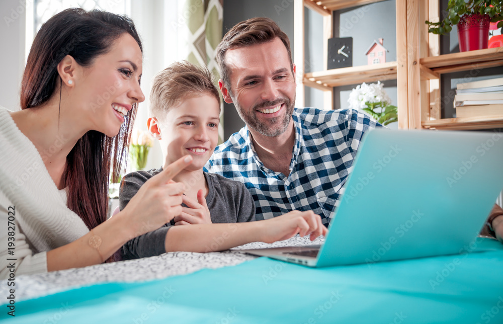 幸福的一家人在家一起使用笔记本电脑