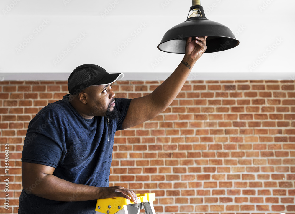 Black guy installing light bulb