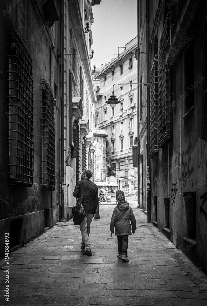意大利热那亚，父亲带着小儿子走在狭窄的意大利老街旁。