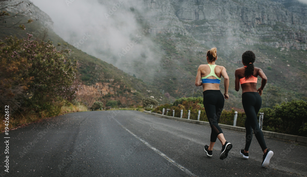 两名女子运动员在公路上奔跑