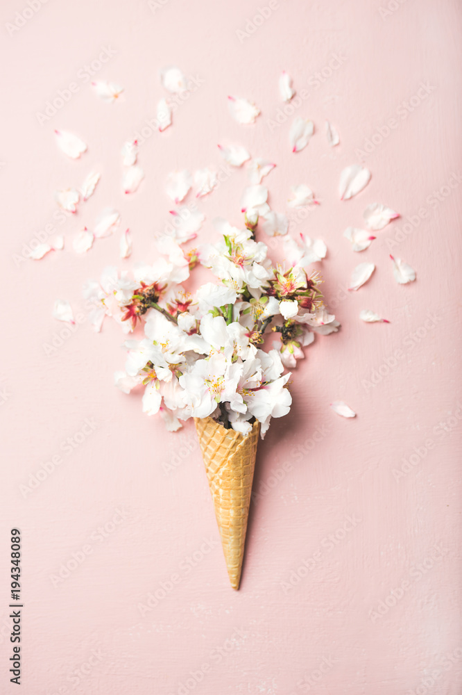 华夫饼干甜筒，柔和的浅粉色背景上有白色杏仁花，t