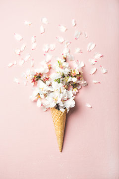 华夫饼干甜筒，柔和的浅粉色背景上有白色杏仁花，t