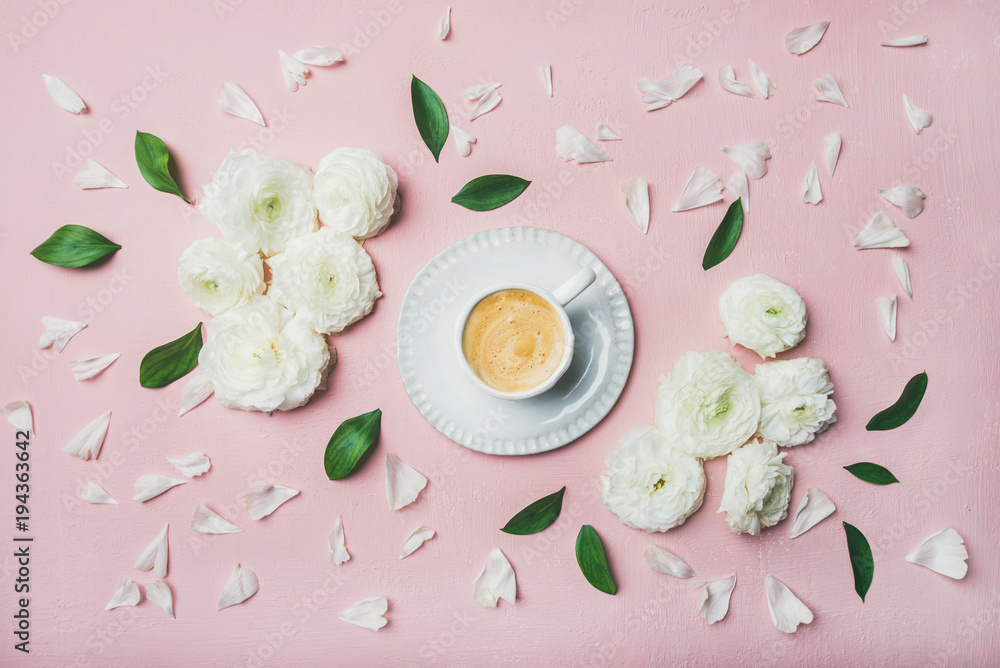 春天早晨的概念。一杯平坦的咖啡，周围环绕着白色的毛茛花和花瓣