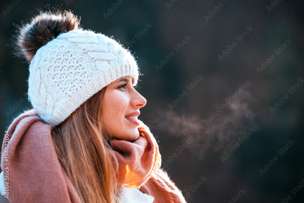 寒冷的冬日，戴着针织毛线帽和大围巾的微笑女人