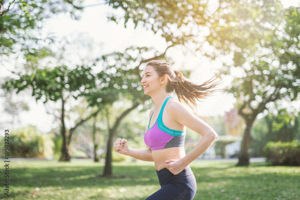 运动型女性户外跑步。行动和健康的生活方式理念。公园慢跑