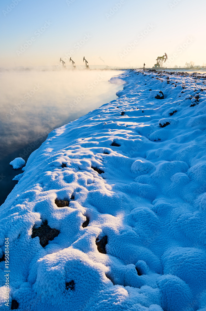 油田里冬季湖畔的美丽雪。