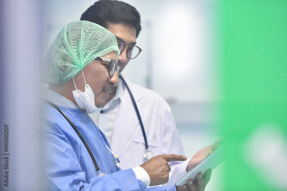 亚洲外科医生团队在手术室使用数字平板电脑