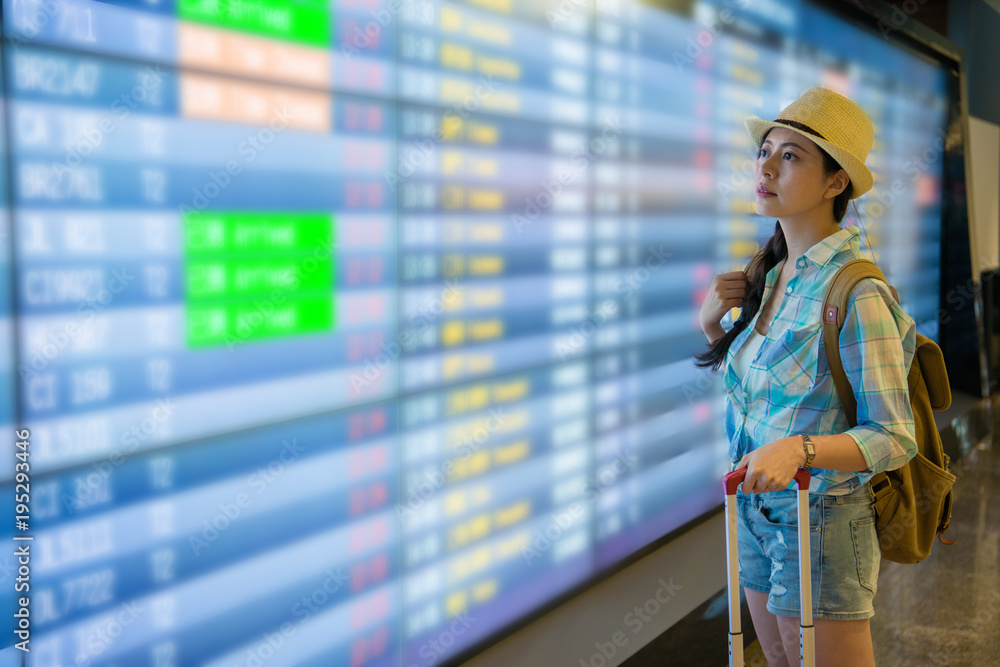 Young woman look at flight timetable worries