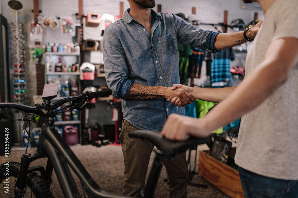 运动商店老板向顾客出售自行车