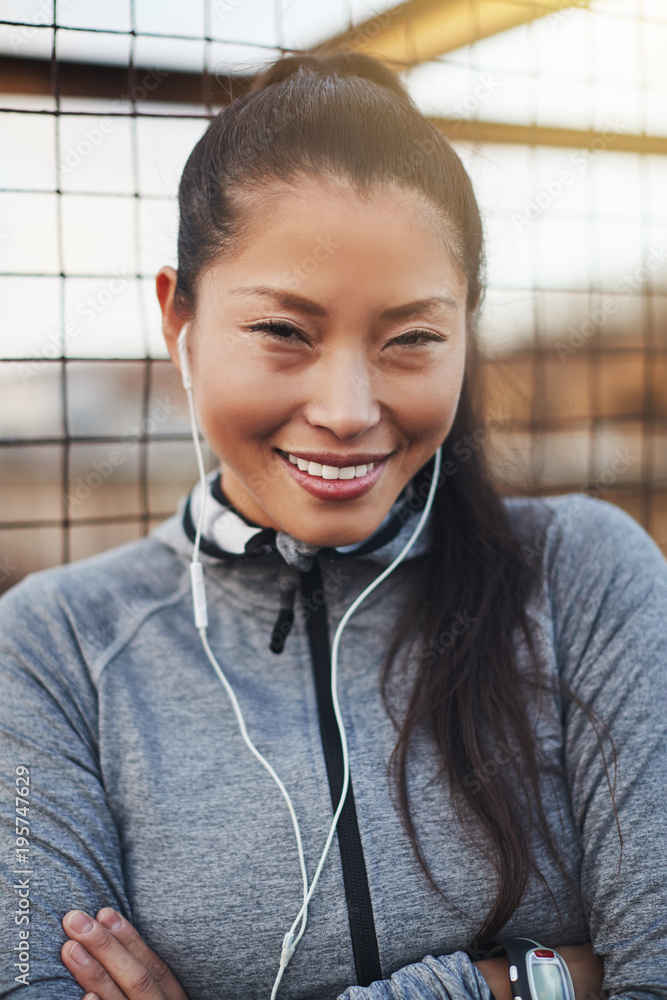 穿着运动服的健康亚洲年轻女子慢跑前微笑