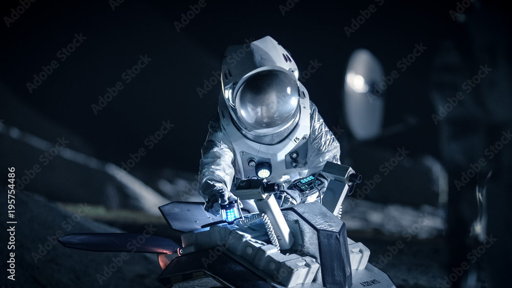 在外星星球上穿着太空服的宇航员为行星表面探测任务准备太空漫游车