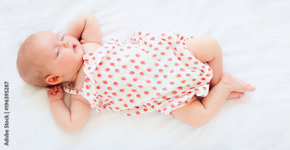 穿着紧身衣睡在床上的可爱女婴。俯视图