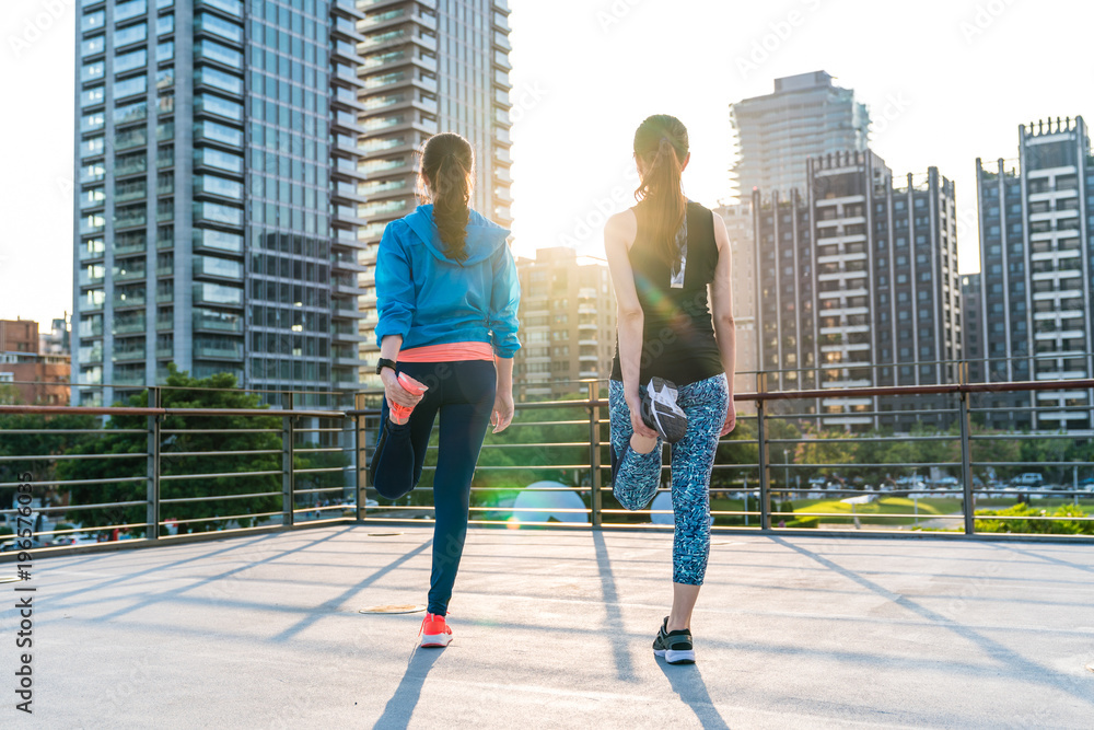 女性在慢跑前伸展双腿以保持健康。