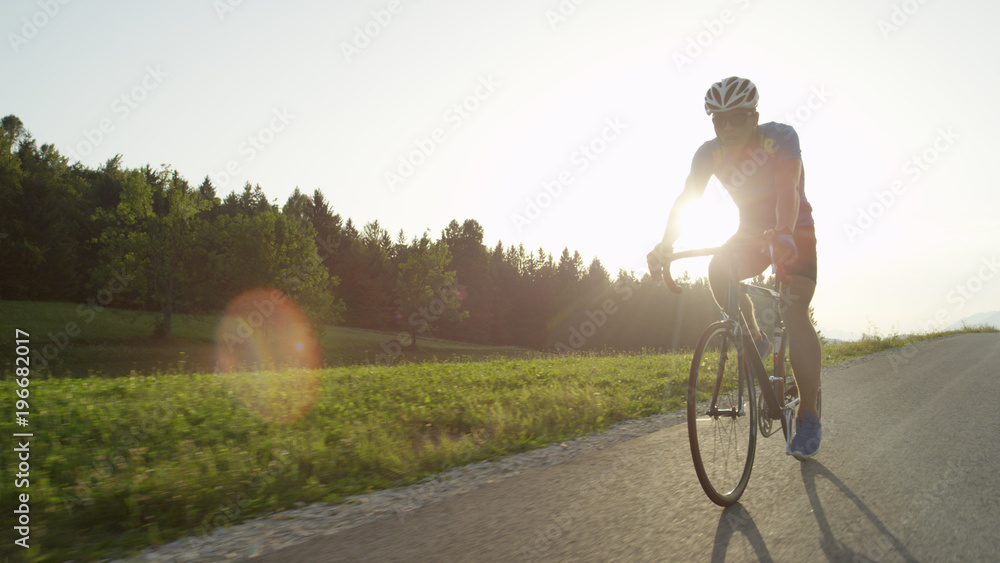 复制空间：职业男性公路自行车手骑着自行车享受阳光巡游。