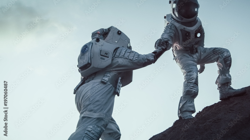 两位宇航员登山，互相帮助，登顶。克服困难，