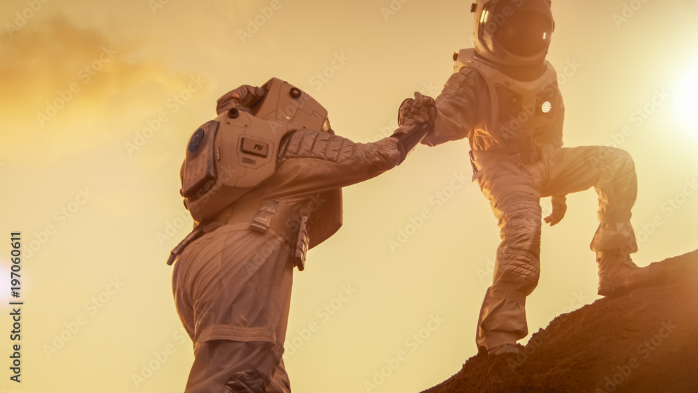 两位宇航员登山，互相帮助，登顶。伸出援手。克服困难