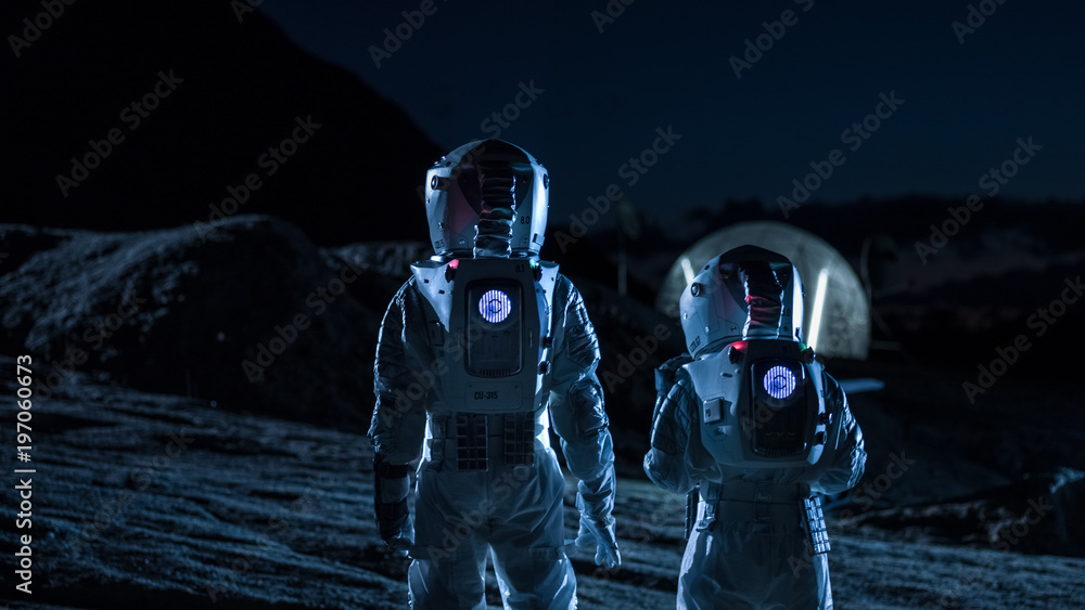 Two Astronauts in Space Suits Walk on the Alien Planet Looking at the Sky. In the Background Base wi