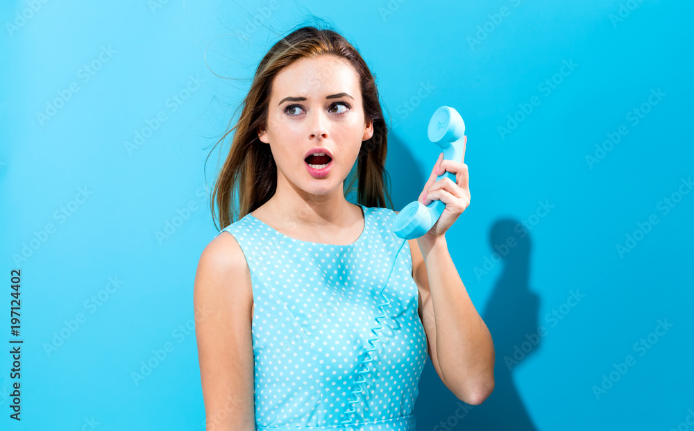 Young woman talking on old fashioned phone