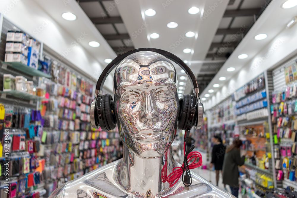 商店里戴着现代耳机的银色光泽人体模型。