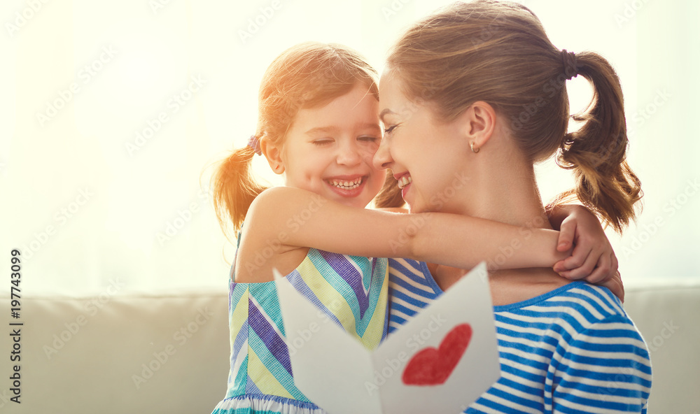 Happy mothers day! Child daughter congratulates moms and gives her a postcard