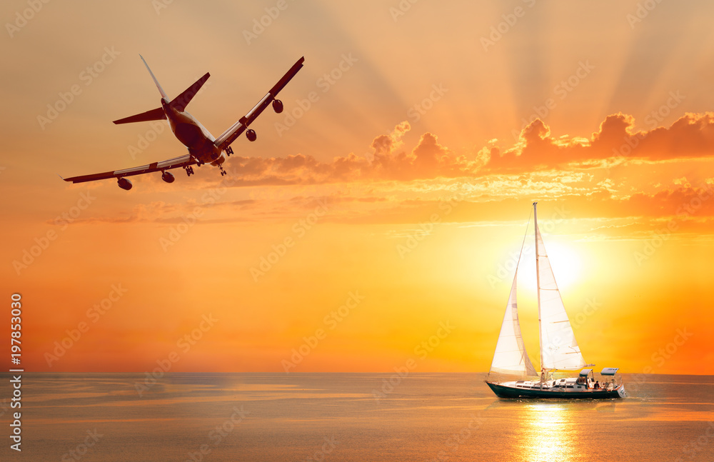 日落背景的游艇和天空中的飞机