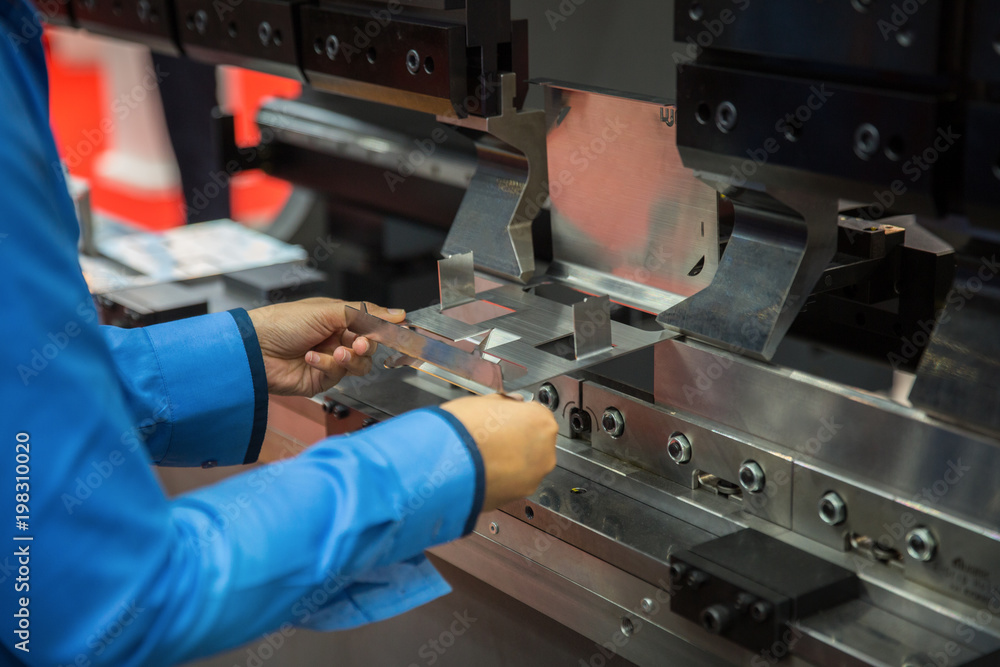 在工厂工作的工人在金属板弯曲工艺中，这种工艺可以用于工厂、工业