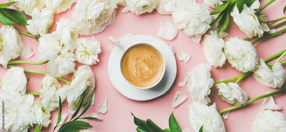 春天早晨的概念。一杯平坦的咖啡，周围环绕着白色的毛茛花。