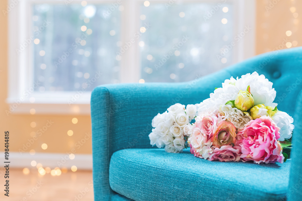 Flower bouquets in large luxury interior home with turquoise chair