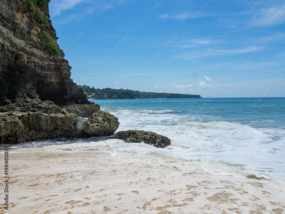 阳光明媚的日子里，印度洋的碧蓝海滩，印度尼西亚巴厘岛的悬崖景观