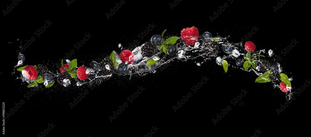 在飞溅的水中混合浆果，在黑色背景上隔离
