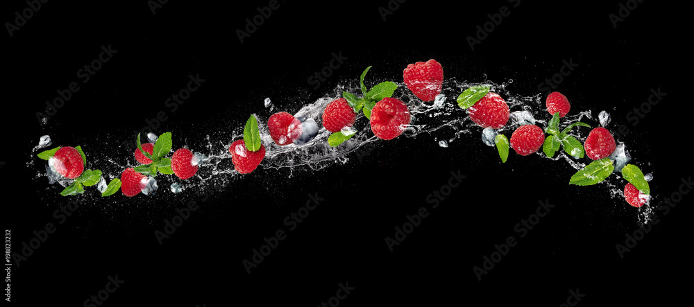落在水中的树莓在黑色背景上飞溅