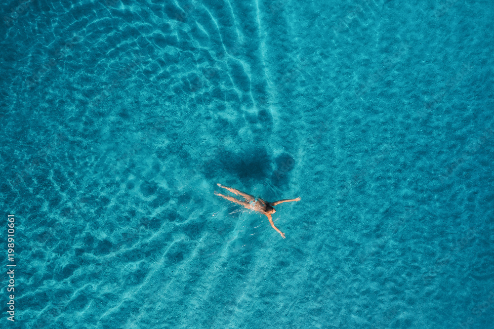 蓝色泻湖中游泳女子的鸟瞰图。土耳其奥卢代尼兹的地中海。夏季海景