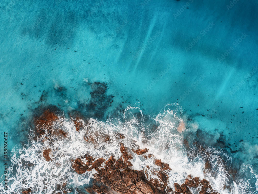 海浪、岩石和透明海洋的鸟瞰图